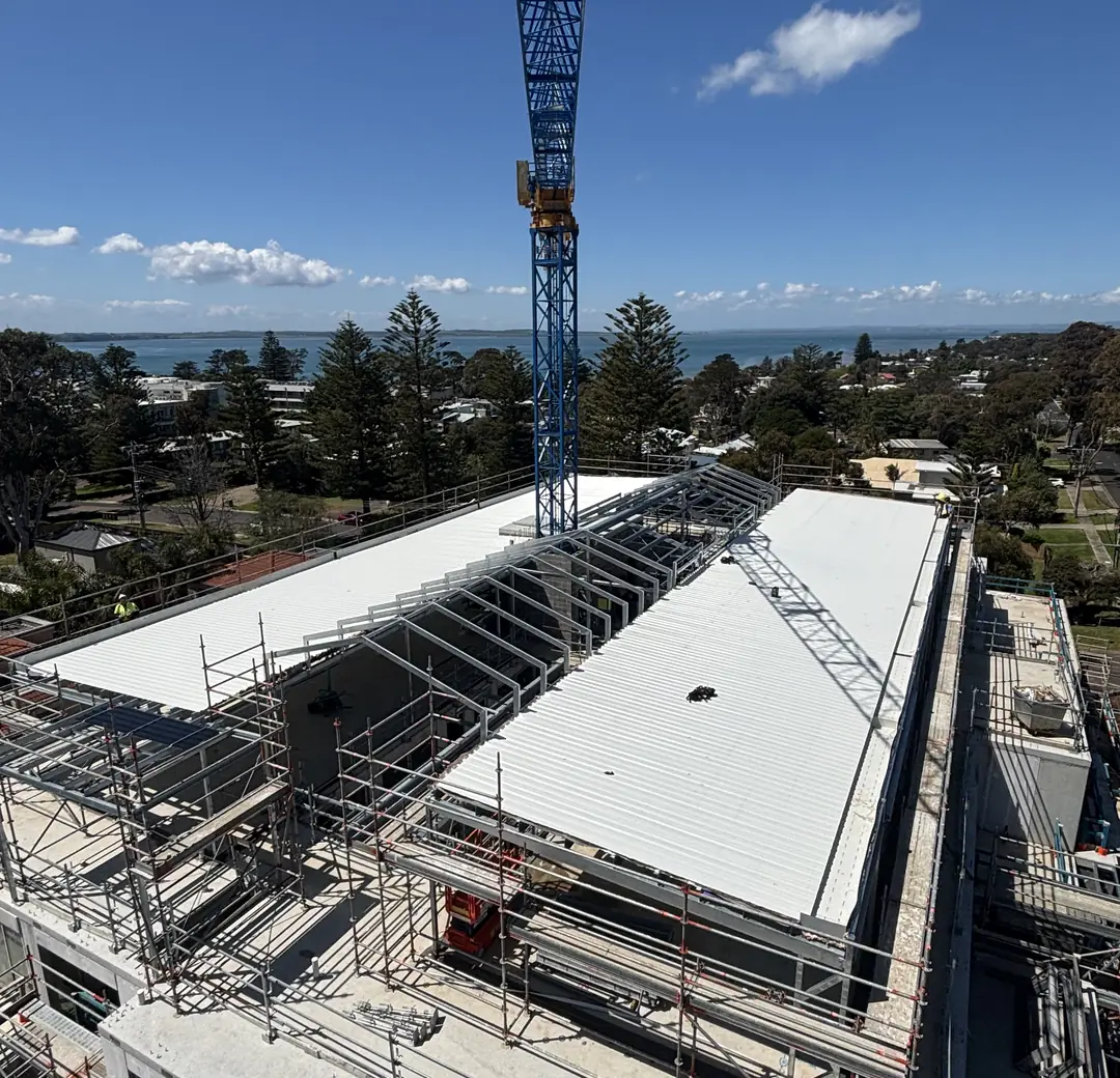Large white metal roof on a commercial building under construction