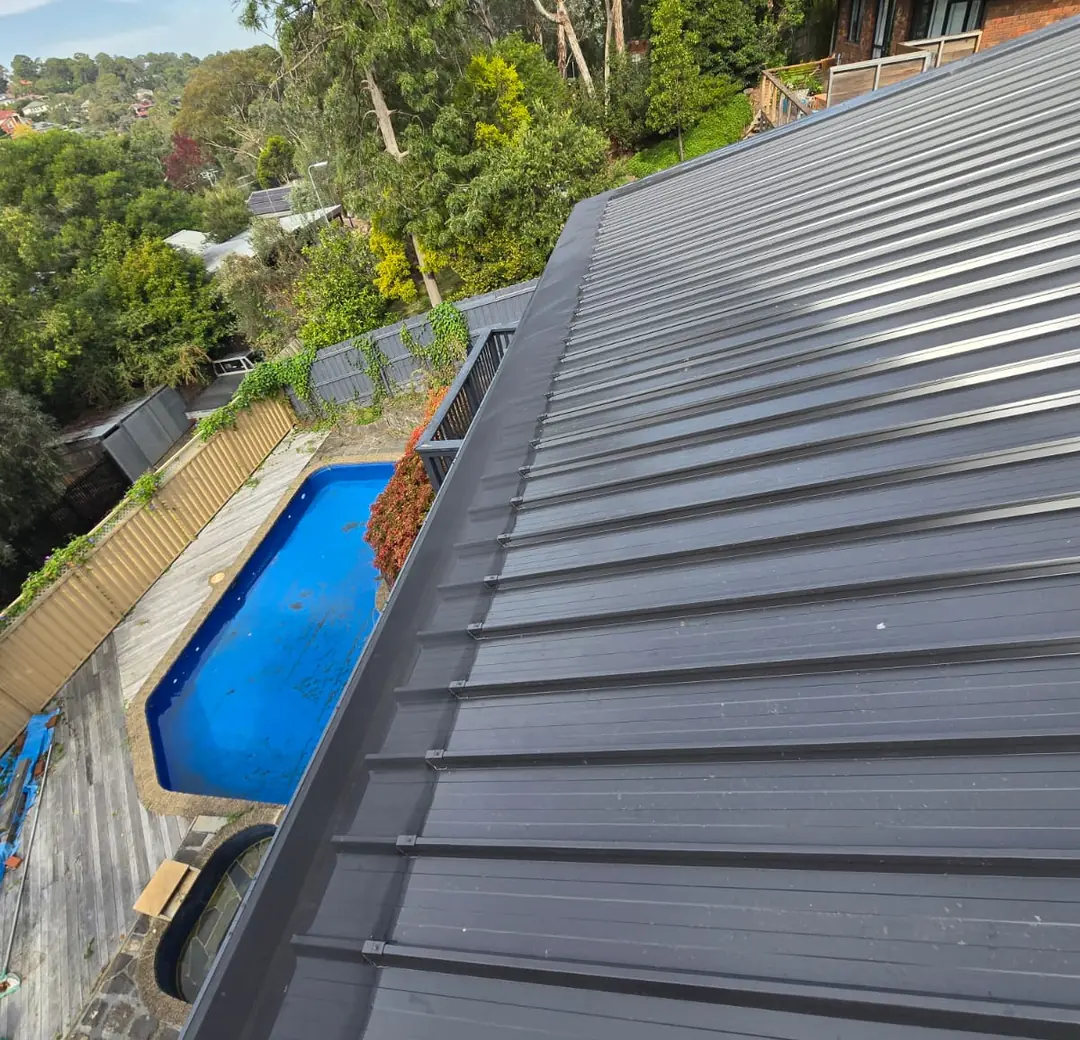 New charcoal metal roof on a home with a pool below