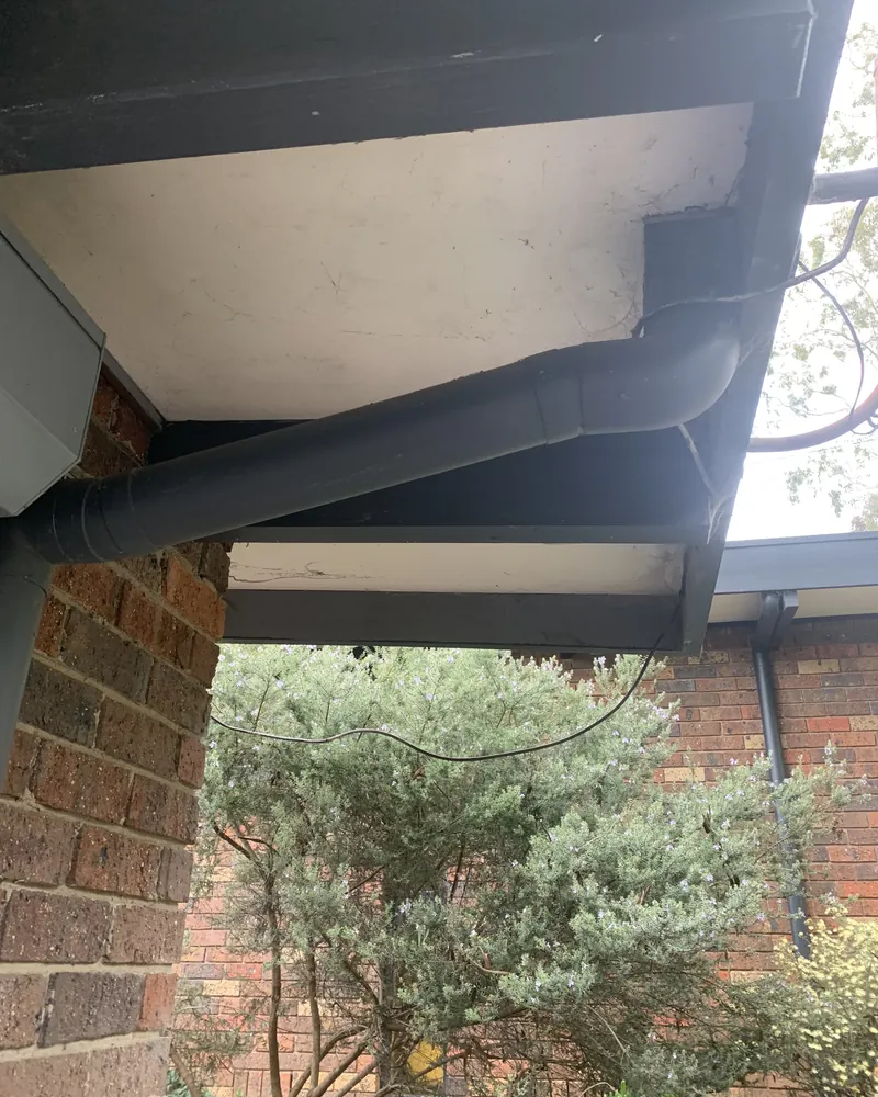 New charcoal gutter and downpipe fitted under an eave