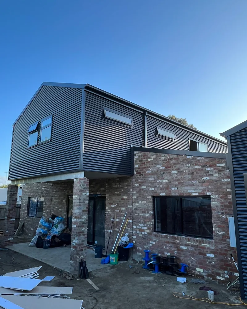 Metal wall cladding on a two storey extension above brickwork