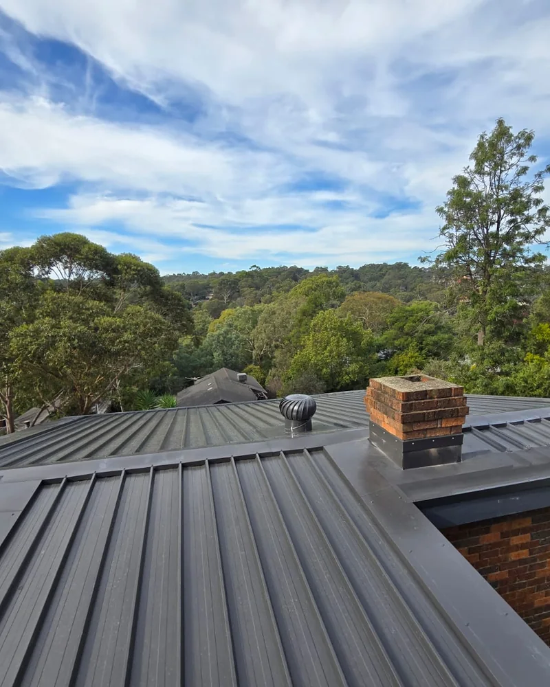 Charcoal metal roof on a home surrounded by trees