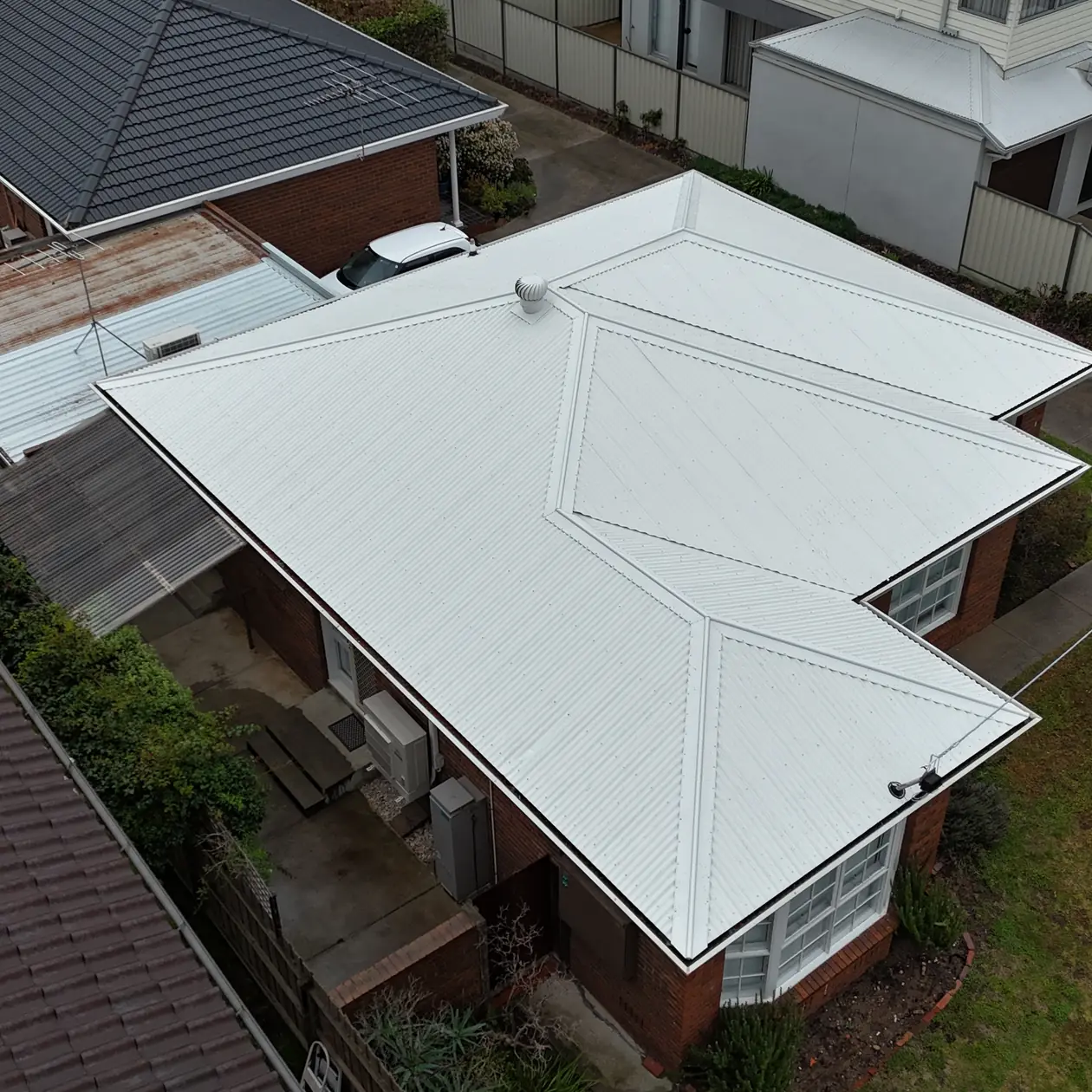 New metal roof replacing a tiled roof on a brick home